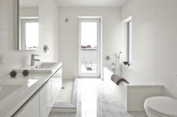 Los baños cuentan con suelos de mármol blanco Carrera, pisos de amortiguación de sonido y bañeras cubiertas con roble blanco certificado por la Sustainable Forestry Initiative